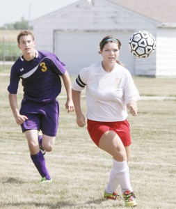 Photo by Keith Stewart ALAH sweeper Natalie Bicknell chases the ball out of the Knight’s territory as Mt. Pulaski forward Eli Grieshiem chases her down Saturday. The Knights dismantled the Hilltoppers 7-2.