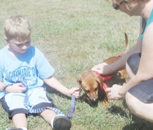 Submitted by Elaine Smith Grady Sparks of Sullivan holds onto his new dog, Mater’s leash after adopting him with his mother Amie at the Findlay Farmers Market Saturday,  August 31.