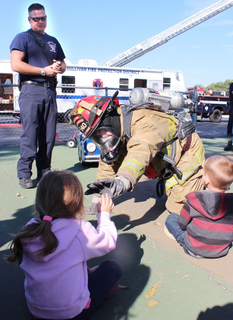 Photo by RR Best Sullivan paramedic Kaleb Randol (background) and Sullivan Fire Captain Chris Wright (front) teach children about fire prevention last Thursday at Agri-Fab’s daycare as part of the nationwide fire prevention week.