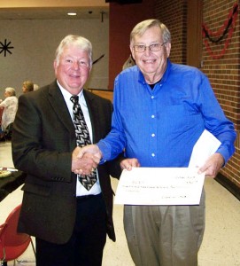 Photo Submitted Sullivan school board chairman Steve Poland receives a $3,250 check from SHS class of 58 president Gary Fish at the annual alumni banquet. Since then, more money has been raised, exceeding a total of $4,000.