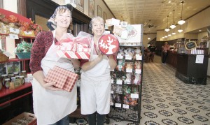 Photo by Keith Stewart Sisters Devon and Ann Flesor, owners of Flesor’s Candy Kitchen in Tuscola, are seen above with various Christmas box and tin candy sets, which will be availble for purchase at this Saturday’s candy sale at the Coffee Bean from 9 a.m.-3 p.m. The sale will donate 20 percent of its proceeds to the Moultrie County food pantry.