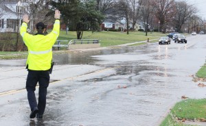 Photo by RR Best A Sullivan police officer waves traffic back away from the Asa Creek bridge in Sullivan Sunday after heavy downpours caused flash flooding. 