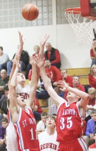 Photo by Keith Stewart Sullivan’s Ty Molzen stretches above two St. Anthony defenders for the rebound Tuesday night.