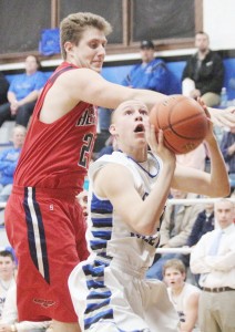 Photo by Keith Stewart Okaw Valley sophomore guard Alex Martin works his way beneath Heritage/Villa Grove 6’4’’ big man Cameron Knell Tuesday night.