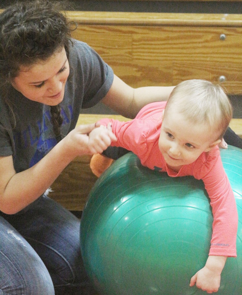 Photo by Keith Stewart SHS student volunteer Cadisen Nuzzo helps Avery Florey balance on an exercise ball last Thursday during the third annual Family Fit Night.