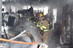 Photo by RR Best Sullivan firefighter Rob Young and Findlay assistant fire chief Jason Fleshner survey the damage inside the home located at 606 West Main Street in Bethany Sunday.