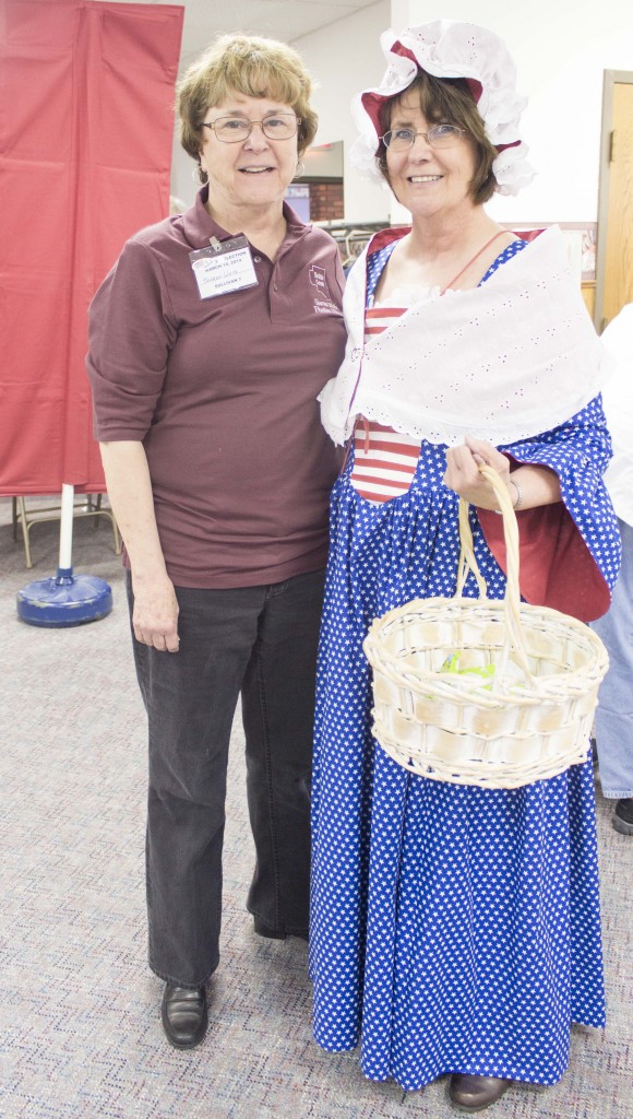 Photo by Keith Stewart Betsy England Moultrie County Clerk Georgia England (right) stands dressed in patriotic wear as Betsy Ross at Faith Lutheran Church in Sullivan during Tuesday’s elections. To her right (left), stands election judge Sharon White, who made the dress in a week using 10 yards of material.