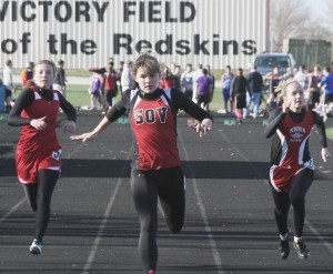 Photo by Keith Stewart Emily Neuhauser lunges forward as she takes first in the 100m dash. (Left) Arthur-Lovington/Atwood-Hammond’s Abby Foreman finishes in fourth.