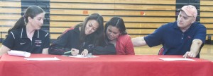 Photo by Keith Stewart Mollie Bowman (left center) signs her letter of intent on April 17 to compete in track and field at McKendree University, as her high school track coach Kali Taylor (left), mother Chonticha (right center), and father Courtice (right) watch.