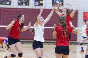 Photo by Keith Stewart The Lady Knights Emily Seegmiller (left), Kim Davis (center), and Brooke Tabb (right) celebrate along with their team after defeating rival Tri-County 25-21, 25-21 last Thursday.