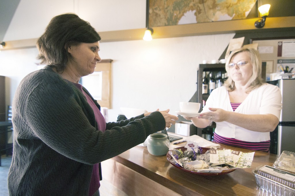 Photo by Keith Stewart Terrie Golden (left) receives her latte from owner Cathrine Craig Tuesday afternoon at 5 West coffee and wine lounge.