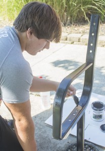 Photo by Keith Stewart Sullivan high school senior Levi Nadler applies a coat of fresh paint to the metal arm of a bench out front of SHS Monday morning. Nadler and six other seniors in the Manufacturing II class have been working to refurbish the three benches the last two weeks.