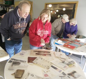 Photo by Barry Featheringill Barry and Karen Golden look at the contents of the time capsule that was opened last Saturday afternoon.