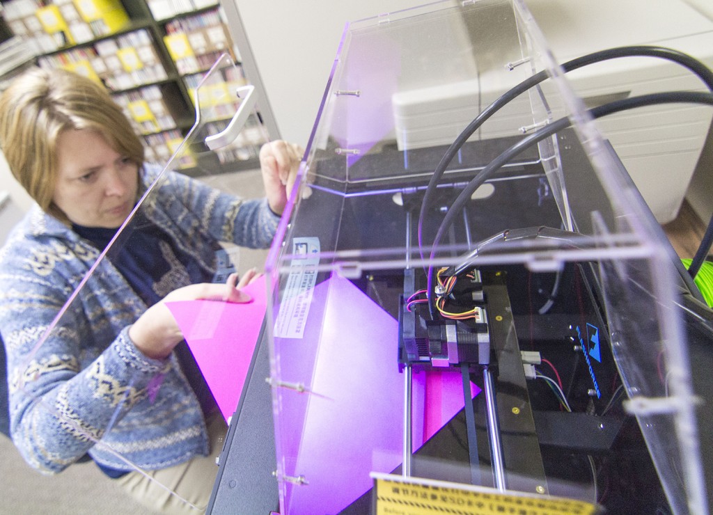 Photo by Keith Stewart Elizabeth Titus Memorial Library children’s librarian Michelle Nolen balances the hot plate of the 3D printer before printing a bookmark Friday.