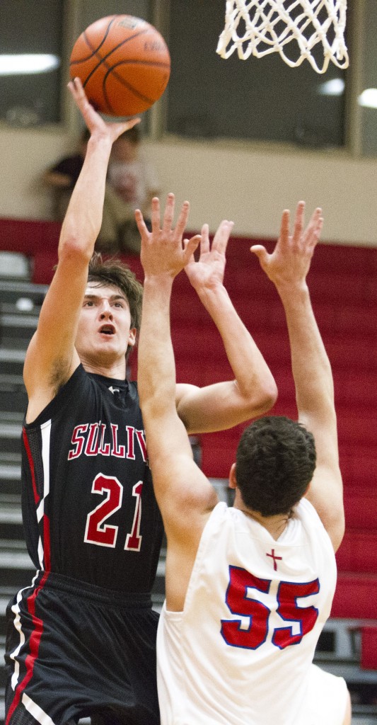 Photo by Keith Stewart Sullivan’s Ty Molzen (no. 21) shoots over St. Anthony’s Derek Rios Tuesday. Molzen led Sullivan with 13 points and 10 rebounds.