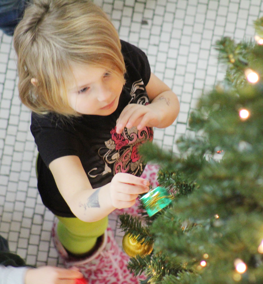 Photo by RR Best Decorating the Tree Sullivan preschooler Natalie Ealy hangs an ornament on the Courthouse Christmas tree Monday morning.