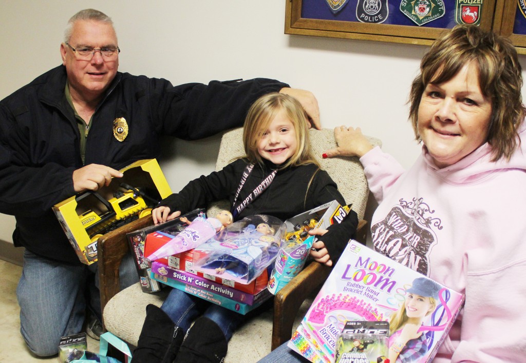 Photo by RR Best Nine-year-old Shalyn Hunter decided to instead of capitalize on her Christmas Eve birthday to donate her presents to the local Secret Santa group. Pictured, from left to right, are Sullivan police chief and Secret Santa organizer John Love, Hunter, and fellow Secret Santa organizer Janet Dirks along with a few of the gifts Hunter donated Sunday.