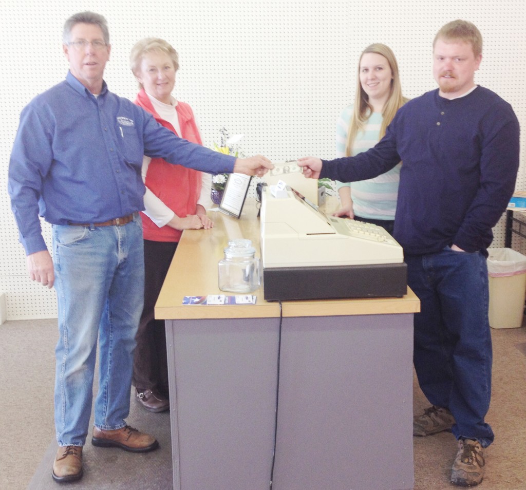 Submitted Pictured are former Muzzy’s Hometown owners Terry and Sharon Muzzy (left) handing the new owners C.J. Swinehart and his wife the first dollar that the business made in an informal sign of the official sale and transfer of the business.