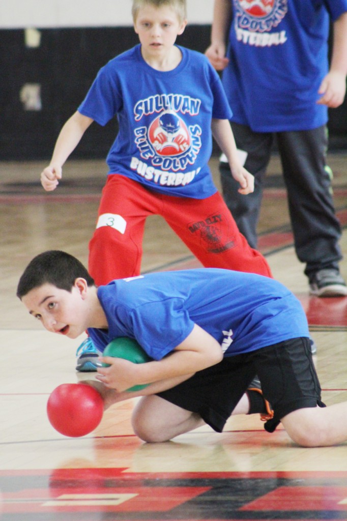 Photo by RR Best 12th Annual Busterball Tourney Fourth grader Wyatt Miller ducks while clutching two balls during the Sullivan Blue Dolphins 12th annual busterball tournament, Saturday March 28 at Sullivan High School. There, 56 teams played with more than 400 participants from ages kindergarten to adult. Teams came from Okaw Valley, Shelbyville, Lovington, and Sullivan. Trophies were given to first place team winners, medals to the second place team winners and a free snow cone was the prize for the team members that exhibited the best sportsmanship for each grade level. A lot of new activities were also available during the event as well, including games, face painting, and a raffle table with a wide variety of prizes.  A full list of winners is posted at http://sbdbusterball.weebly.com/.