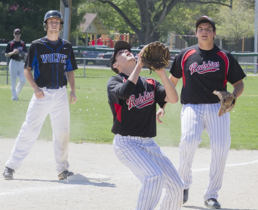 Photo by Keith Stewart Sullivan pitcher Jacob Piper eyes an in-field popup while first baseman Dakota Clayton supports and Okaw Valley base runner Justin Johnson watches in anticipation.