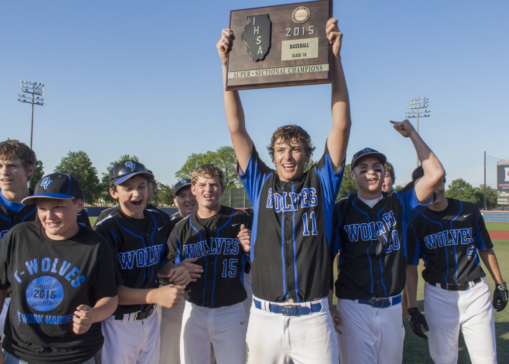 Photo by Keith Stewart Okaw Valley senior Devon Still hoists the team’s super-sectional plaque into the air for the home crowd to see Tuesday night in Champaign after he and the Timberwolves defeated Princeville 6-5. 