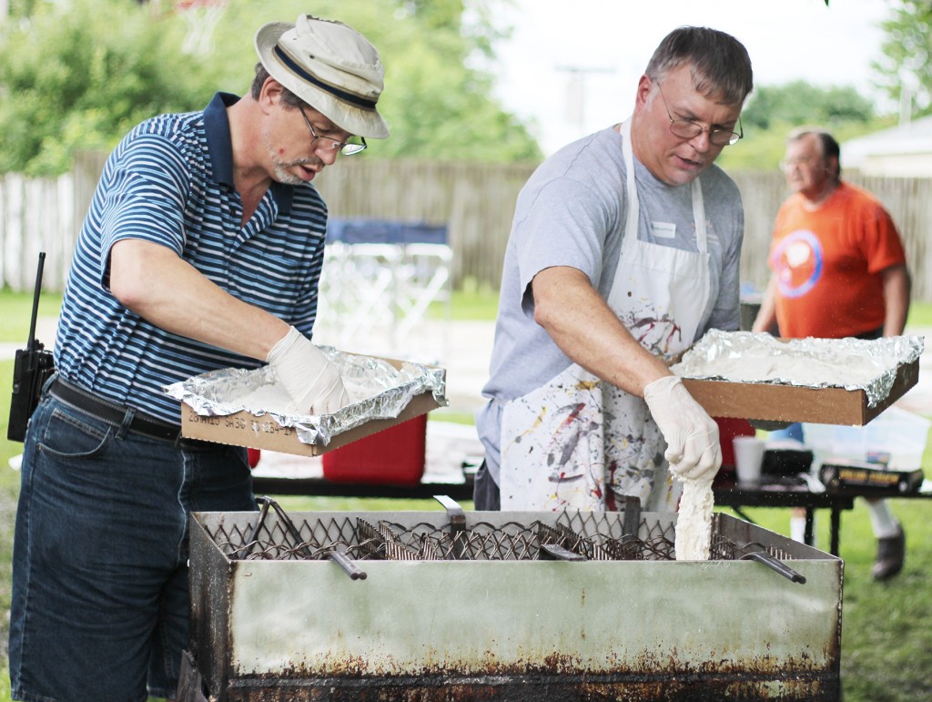 Photo by Darian Hays Frying Fish Pictured are Steve Fleming(left) and Ralph Zancha (right) frying pollock during the annual Lovington fish fry held June 26 in Tom Conn Park.  According to Carol Smith of the Community Club, which sponsored the fish fry, approximately 140 pounds of fish were cooked, 200 people served, and $800 raised.