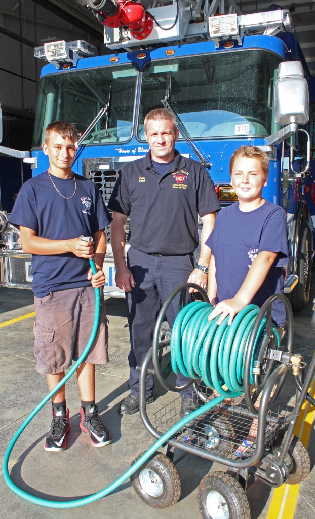 Photo RR Best YOUNG FIREFIGHTERS- Leyton Burcham (left) and Patrick Owens took quick action and their garden hoses to the Jim Smith house in Country Estates Sunday. Sullivan Firefighters representative Kenny Graven (center) was on hand to present the young volunteers with Sullivan Fire Department shirts.