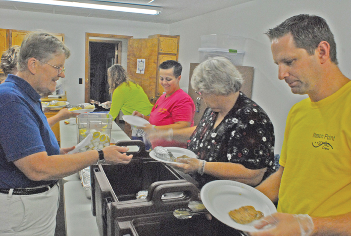 Photo by Mike Brothers Sixty-two people from Sullivan and surrounding communities gathered at the Mid-Illinois Senior Services for lunch Friday, Aug. 21 in observation of National Senior Citizens Day. On this day in 1988 President Ronald Reagan made the official declaration. Mason Point provided lunch for the group  celebration. Above Executive Director Deb Groendal is served her meal by Darin Wall, Karen Rodgers, Leeann Stickles and Angie Clawson.