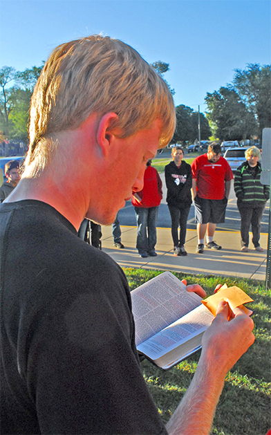 Photo by Mike Brothers See You At the Pole Pictured above senior Blake Stewart reads scripture prior to the group prayer.  Sullivan school students, staff and community members gathered around the flag pole at Sullivan Middle School for the annual “See You At the Pole” prayer at 7:30 a.m. Wednesday, Sept 23. The event was coordinated by parent Amy Diener. Senior Adam White gave some background on the event.  Scripture and prayers were given for the faculty, administration and students.