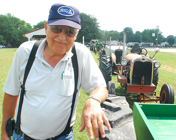 Photo by Mike Brothers Tom Gregory’s antique tractors form a line behind him and along Highway 121 in Bethany to honor the Farm Progress Show in Decatur. Gregory returned the tractors to the shed after the show and replaced the display with some of his favorite Model A Ford cars and trucks.