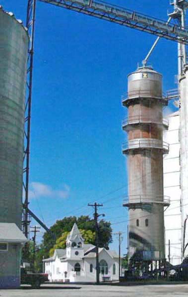Photo by Glenn Austin Blessed Harvest Nestled among the Bethany Grain Company’s grain bins is the century old Bethany Cumberland Presbyterian Church watching over the harvest.