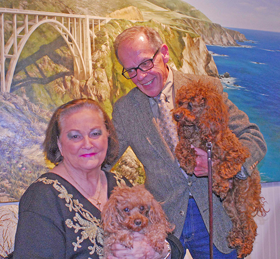 Photo Mike Brothers Arthur gallery owners Joan and Jerry Winters pose in front of a mural of their former home in Carmel, Calif.  along with store pets Monet and Manet.