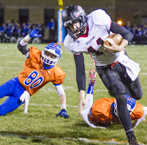 Photo by Keith Stewart SOV quarterback Ty Molzen tries to stay upright while carrying the ball past two Newton defenders Saturday night. Molzen would lead the Redskins in rushing with 62 yards on 14 carries, while completing 13 of 23 passes for 88 yards and two interceptions.