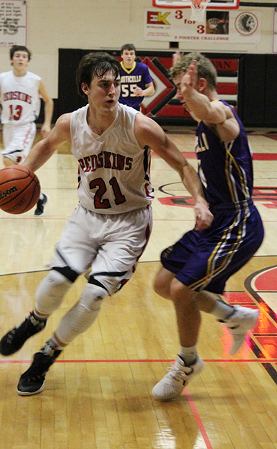 Photo by Mike Brothers Redskin Senior forward Ty Molzen pushes toward the basketball for two of his seven points against Monticello.