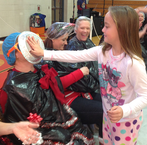 Photo Courtesy Sullivan Schools Good Behavior Brings Big Fun Good behavior received a big reward for students at Sullivan Elementary School last week. Students got to have some good fun by throwing pies into the faces of teachers and administrators December 18. Above Ruby Haegen hits first grade teacher Eudora Drollinger square in the face with a cream pie.