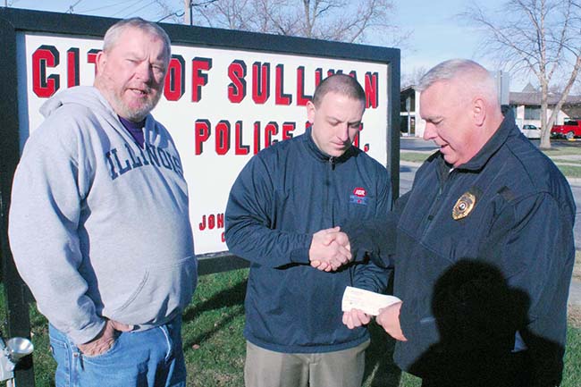 Photo by Mike Brothers Sullivan IGA donated $500 to Secret Santa. IGA manager Pat Stinson  (center) presents check to Secret Santa representatives Police Chief John Love (right) and Greg Foster.