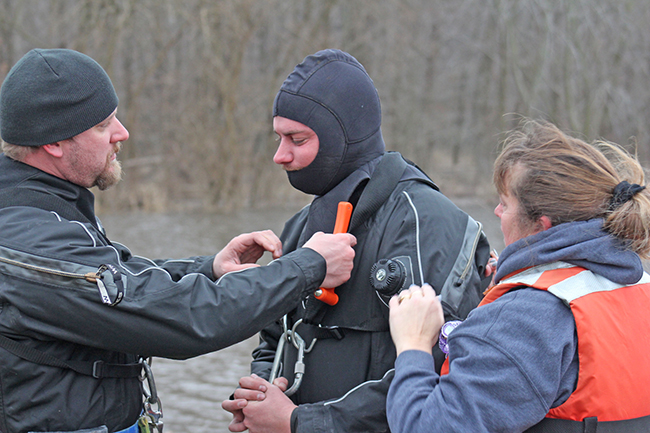 Photo by RR Best Moultrie County dive team members Jesse Scribner, Rob Martz and Amanda Farley secure equipment before diving down to hook the submerged car from the drink.