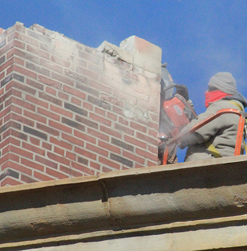 Photo  by Mike Brothers Leaky Chimney Comes Down Masons Masonry Restoration workers cut through the cap on the abandoned courthouse chimney which had recently allowed water into the state’s attorney’s office. Short order was made of the removal during some of the coldest and windiest days of the year. Cost to the county was not to exceed $18,500.