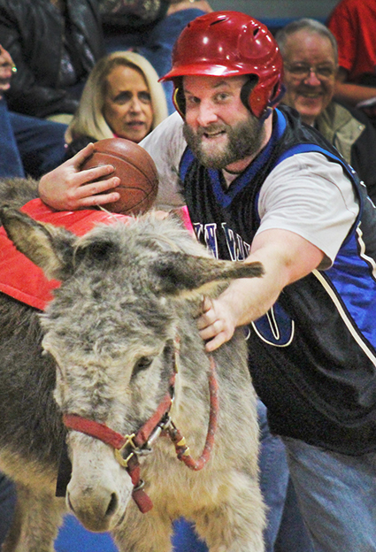 Photo By Sonya Best Sean Kirksey deals with the classic problem during the Okaw Valley FFA donkey basketball challenge in Findlay Saturday, March 19. How to get back in the saddle with a basketball in your hand. Thrills and spills filled the evening with the students falling to the more experienced administration team. View more photos here.