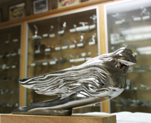 Photo by Mike Brothers Elizabeth Titus Memorial Library has a historic automobile hood ornament and radiator cap collection on display. Donated to the library by O.K. Jobbers founder and collector Lynn R. Huntsburger (1914-2005), glass cases filled with hood ornaments such as this one from 1941 and radiator caps from the earliest automobiles are available for public viewing. 