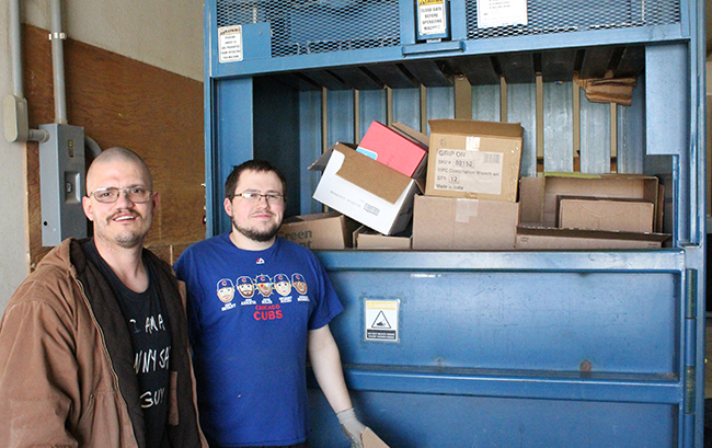 Photo by Mike Brothers Above Joe Ellis and David Cornwell load the box crusher, preparing cardboard collected from area businesses for recycling. At right Executive Director Susan Rauch checks photo display strip which helps consumers with autism deal with schedule changes.