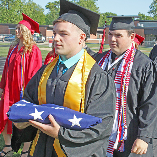 Photo by Mike Brothers Pomp and Circumstance-Sullivan High School seniors Evan Baker holding the flag and Ben Berner line up during the processional Sunday. It was the 138th high school commencement held at 5 p.m. May 15 on the high school football field. 