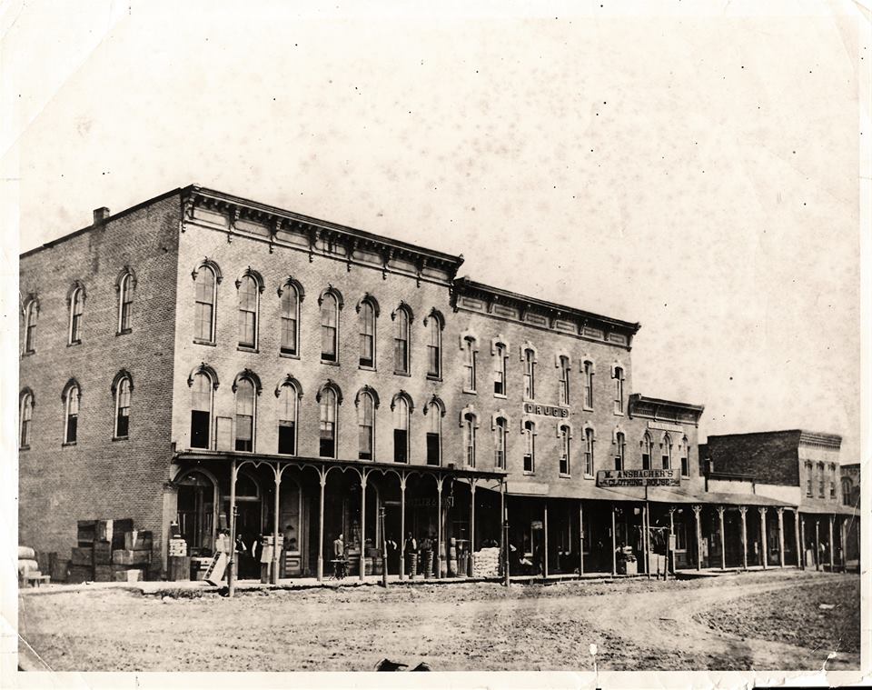 Pictured above is the north side of square in Sullivan in1881. The far left 3-story building is theTitus Opera House. The second floor corner office is John R. Eden Law Office. The first floor corner is a general store. Standing in front of the stairs to the Opera room and next to his new sewing machine is G.O. Andrews, a tailor. Next is L.M. Spitler and his son. Occupying the Vadakin “Drugs” building was Mose Ansbacher, men’s clothing. Where TNT is today was occupied by the “Journal” newspaper. Harry J. Pike, Jeweler occupied one of the small wooden buildings, and Dr. Lewis was located in the end building. Photo taken by A.S. Creech and is oldest known photo of that side of square. Please submit photos to the News Progress for future consideration. Originals will be saved for return or forwarded to Moultrie County Historical Society. If you have any other information, please contact the Moultrie County Historical Society at 217-728- 4085.