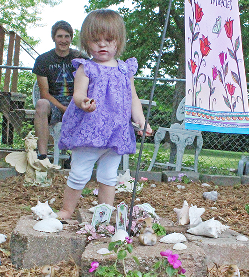 Photo by Bernie Sanders Fairy Garden Sullivan gardener Tia Punches spent the week creating a Fairy Garden, sprinkled with shells collected from various beaches over the country. Above Tia’s great-granddaughter Harlequinn inspects shells from the garden while grandson Sebastian looks on.