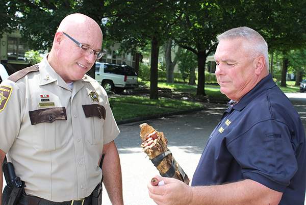 Photo by Mike Brothers Sullivan Chief of Police John Love (right) shows Moultrie County Sheriff Chris Sims the bundle of flares that looked like dynamite to the person who reported its location to authorities last week.