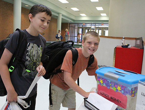 Photo by Mike Brothers First Day at SES While most area schools started last week Sullivan schools’ summer construction delayed opening until Monday. Now schools have new HVAC units, communications and security systems along with a roof to keep students dry. Above Luke Waelde (left) and James Rose are paying ahead for lunch as students at Sullivan Elementary School are dropped off by parents and gather in the gymnasium prior to attending classroom.