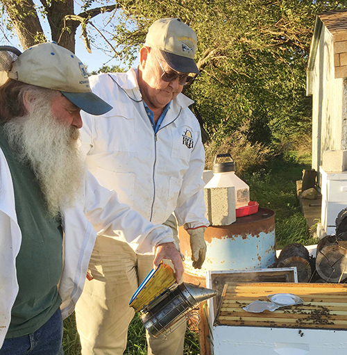 Photo by Emily Stutzman Beekeepers Tom Vance and John Durbin smoke bees to lure them into hives where the workers make some of the sweetest local honey in the country.