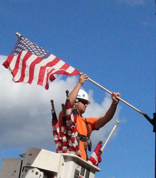 Photo by Mike Brothers Flags Wave Sullivan utility workers put the crowning touches on the city’s Labor Day weekend placing flags around town Friday in preparation for the last holiday of summer.