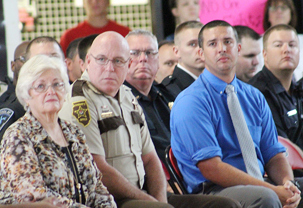 Photo by Mike Brothers Patriots Day reflections were depicted in a video watched by the assembly at Sullivan High School. Above Sullivan Mayor Ann Short, Sheriff Chris Sims, Chief of Sullivan Police John Love and guest speaker Nathan Becker watched somber memories from 9-11-01.