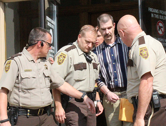 Photo by Mike Brothers Convicted of murder Michael Yost is escorted from Moultrie County Courthouse Sept. 15 by Sheriff Chris Sims (right) Chief Deputy Gary Carroll (left) and Deputy Gary Eller (second from left). Yost remains in Moultrie County Jail until his sentencing October 21.